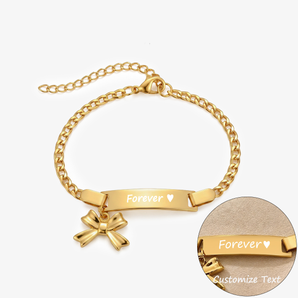 ゴールドのカーブバーブレスレット。リボンチャーム付きで、Foreverとハートの刻印と刻印部分のクローズアップ